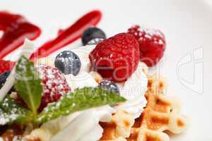 waffle and cream topped with fresh berries