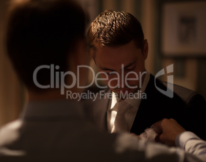 groomsman fixing boutonniere