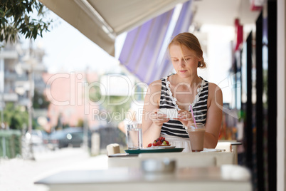 woman with phone in outdoor cafe