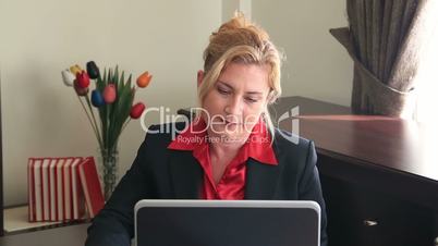 Businesswoman using laptop and writing