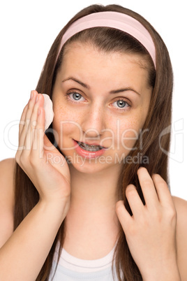 girl cleaning face with cotton pad isolated