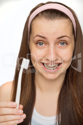 girl wearing braces showing toothbrush