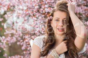 girl with braces posing near blossoming tree