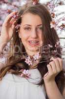girl with braces holding blossoming tree branch