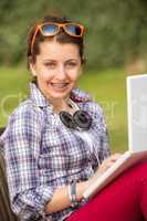 student with braces using laptop at park