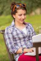 girl using laptop sitting bench at park
