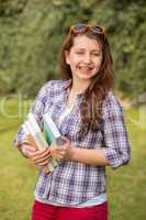 cheerful student with braces holding books outside
