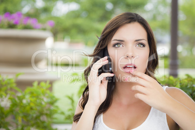 Stunned Young Adult Female Talking on Cell Phone Outdoors