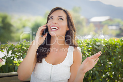 Young Adult Female Talking on Cell Phone Outdoors on Bench