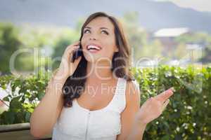 Young Adult Female Talking on Cell Phone Outdoors on Bench