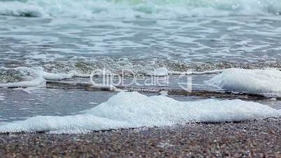 Beach sand textured background with waves coming an going back to the ocean