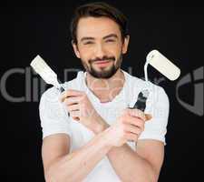 Smiling painter holding a roller and brush