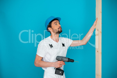 Workman in a hardhat holding a drill