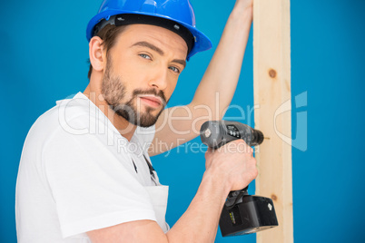 Carpenter drilling a hole in a plank of wood