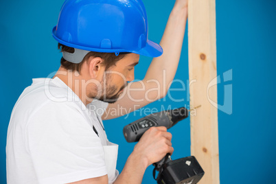 Carpenter drilling a hole in a plank of wood