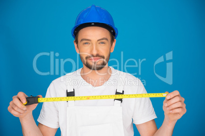 Smiling workman holding a tape measure