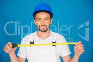 Smiling workman holding a tape measure