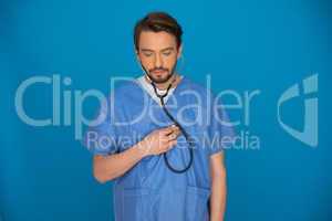 Doctor holding a stethoscope staring at the floor