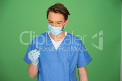 Male doctor or nurse looking at his gloved hand