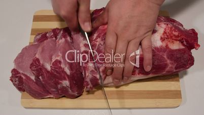 Male hands cutting fresh pork meat
