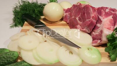 Dolly: Sliced fresh pork meat and vegetables on wooden cutting board