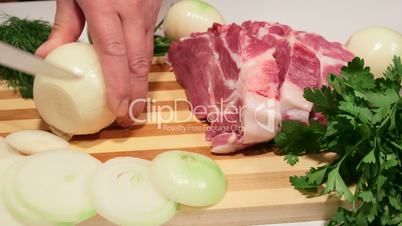 Male hands chopping onion for pork meat cooking