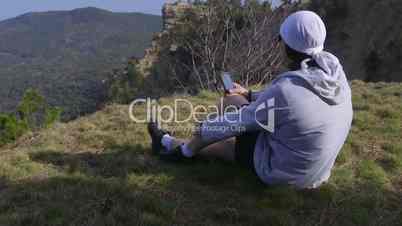 Woman listening to music on the mountain top