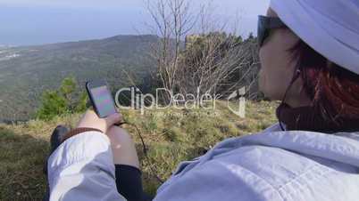 Female hiker with smartphone at mountain top