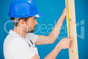 Carpenter or builder measuring a plank of wood