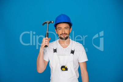 Smiling workman holding up a hammer