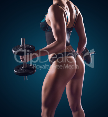 Muscular athletic woman working out with weights