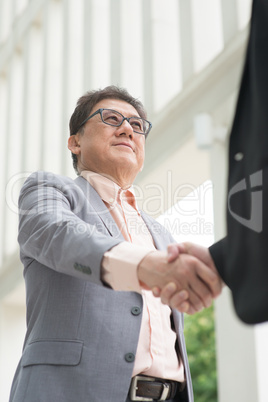 asian businessmen handshaking