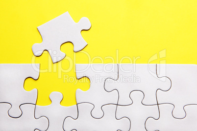 White puzzle pieces on yellow background