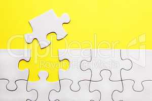 White puzzle pieces on yellow background