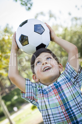 Cute Young Boy Playing with Soccer Ball in Park