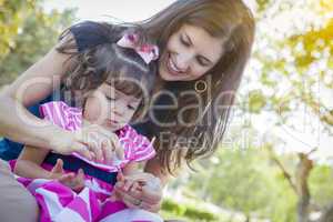 Young Mother and Cute Baby Girl Applying Fingernail Polish