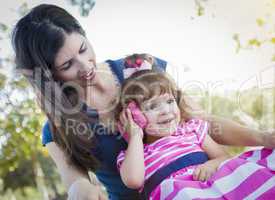 Mother and Cute Baby Daughter Playing with Cell Phone