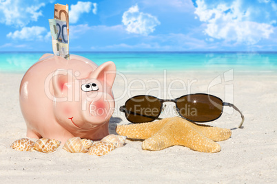 Sparschwein mit Geldscheinen und Sonnenbrille am Strand