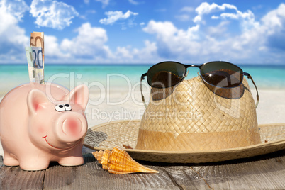 Sparschwein, Strohhut und Sonnenbrille auf dem Holzsteg