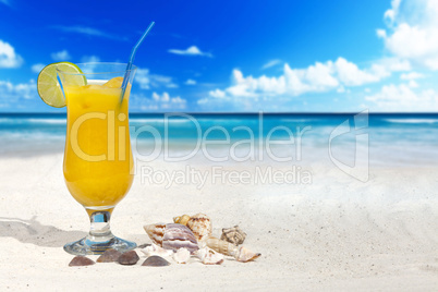 Fruchtcocktail und Muscheln am Strand