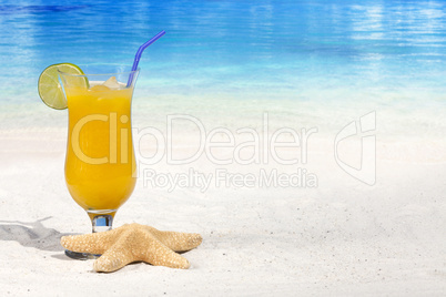 Fruchtiger Cocktail und ein Seestern am Strand
