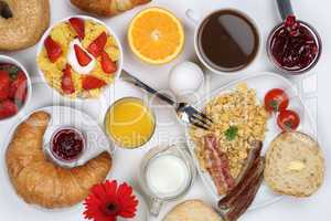 frühstück mit müsli, kaffee, rührei, früchten und brötchen