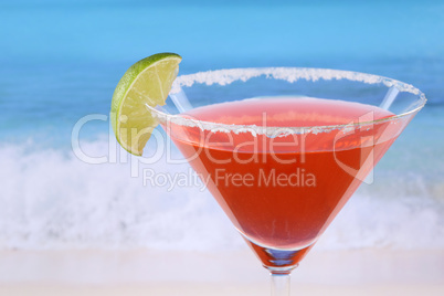 roter martini cocktail mit limette am strand