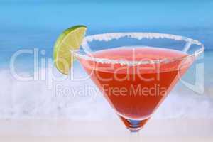 roter martini cocktail mit limette am strand