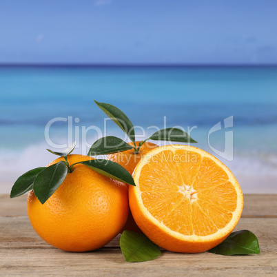 frische orangen früchte am strand und meer mit copyspace