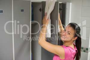 woman placing towel on locker door