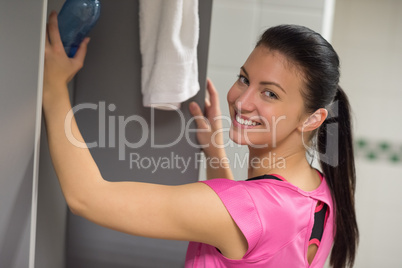 woman putting water bottle in locker