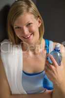 woman holding water bottle in locker room