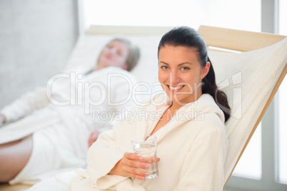 smiling woman with water glass at spa