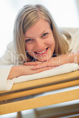 happy woman lying on bed at spa